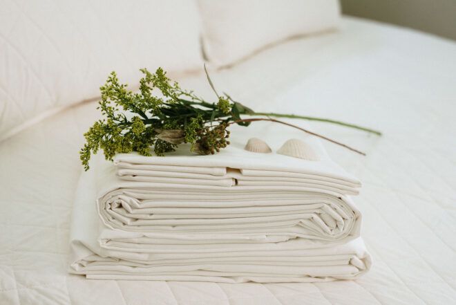 A pile of white cloth with a green bundle on top of it