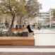 A brick sitting area that surrounds a tree