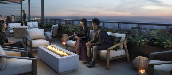 People sitting on a white chair huddling over a rectangle fire pit