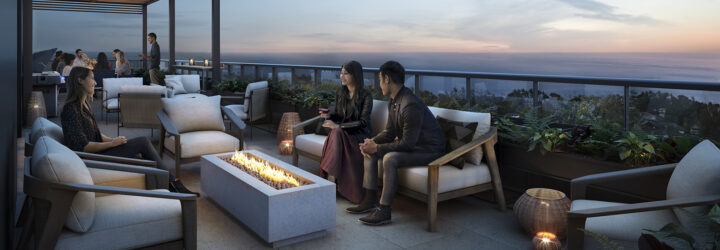 People sitting on a white chair huddling over a rectangle fire pit