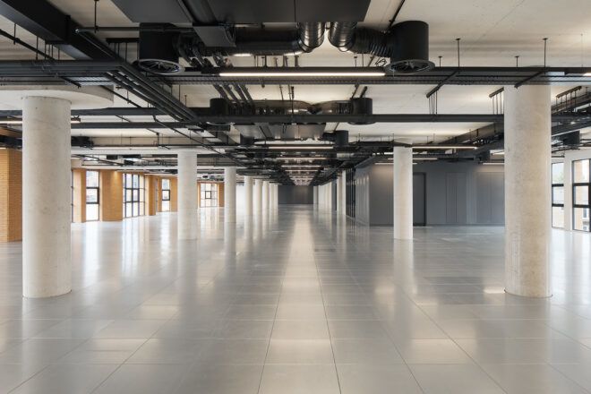 An open hallway area with exposed piping on the ceiling
