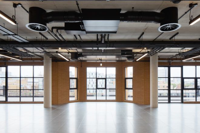 An indoor open hall area with a wall covered in windows