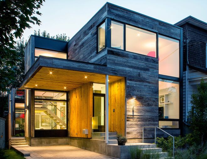 A two story barn house with the interior has its lights on