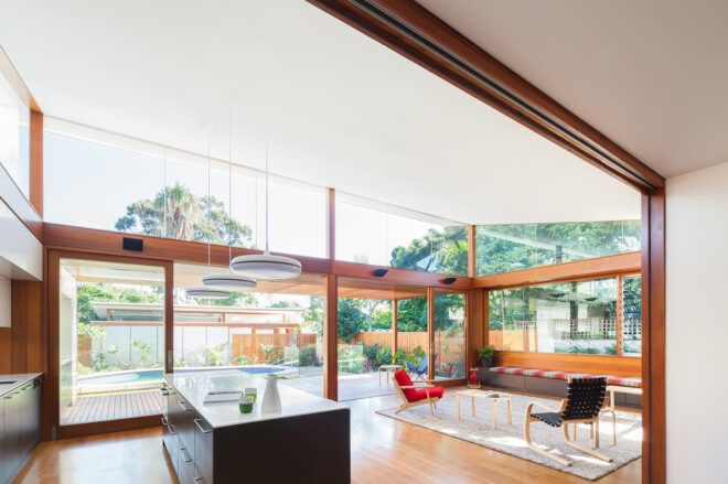 A living room and kitchen area filled with windows