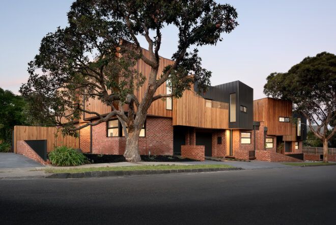 A two-story wooden house sitting behind a street