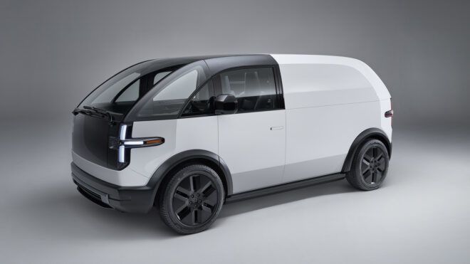 A white Canoo van vehicle sits in an empty room