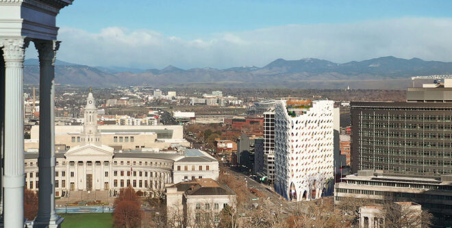 A white hotel building stands amidst a city landscape