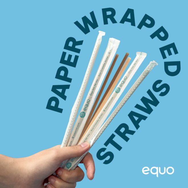 A hand holding paper wrapped straws