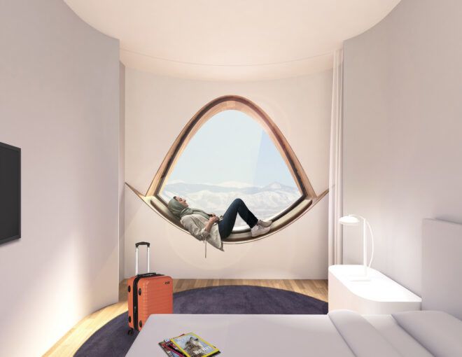 A person lounging on a half circle window in a bedroom suite