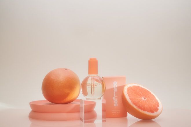 A clear bottle with grapefruits set against it