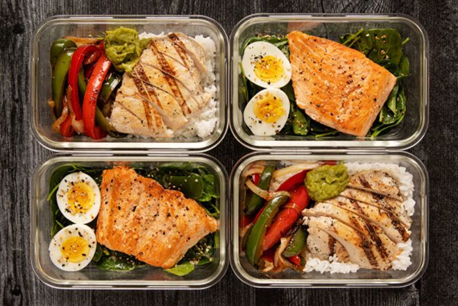 Four plates filled with food such as salmon and egg and vegetables