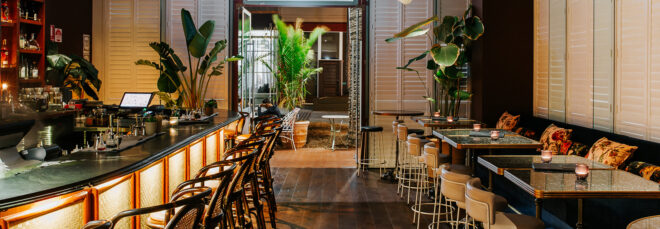 An inside parlor of an Ovolo hotel chain features a bar on the left and seating area on the right