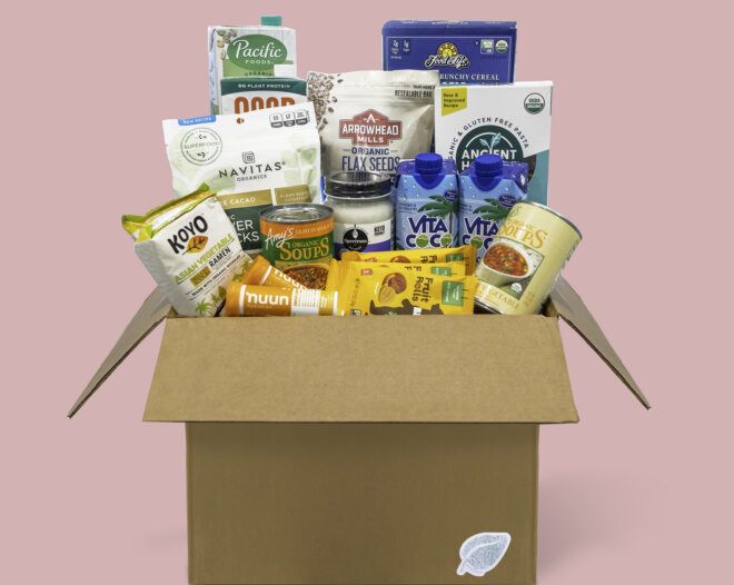 A box filled with food against a pink background