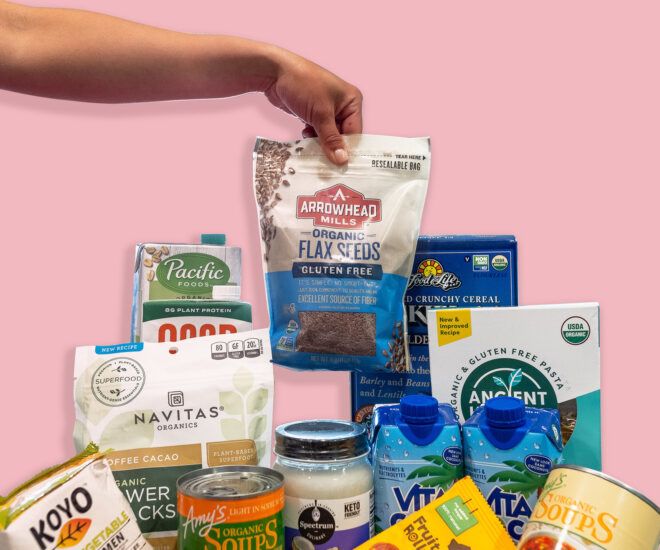 A hand holding up a pack of food amidst a pile of food