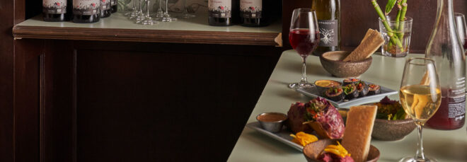 A table of food with wine glasses filled with red and white wine
