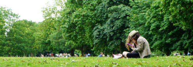 A woman sitting on a grass park area