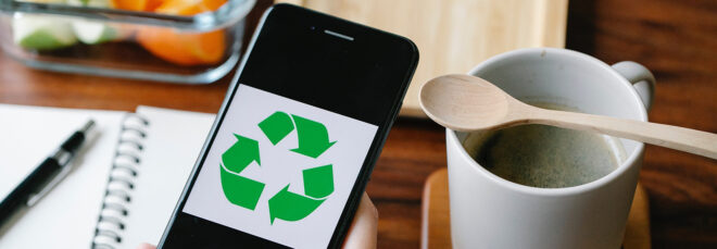 A black phone and on the screen is the green arrows recycling symbol