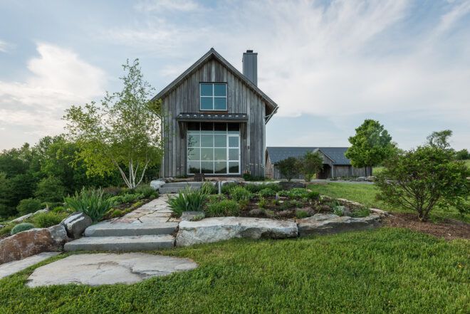 The side of a farmhouse with stone steps leading up to it