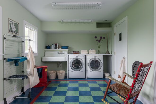 A washer room for clothes with blue tiled floors
