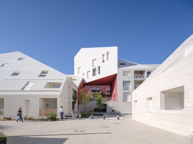 A pathway leading to white buildings in varying sizes