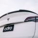 The back of a Tesla white car with the license plate reading ADRO