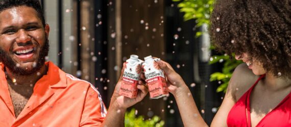 Two Black people clinking buzzbox drinks