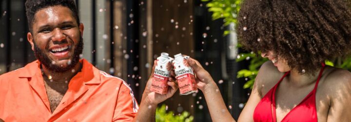 Two Black people clinking buzzbox drinks