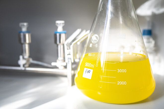 A beaker filled with a yellow fluid