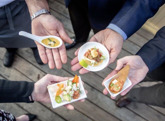 Four hands holding different appetizers