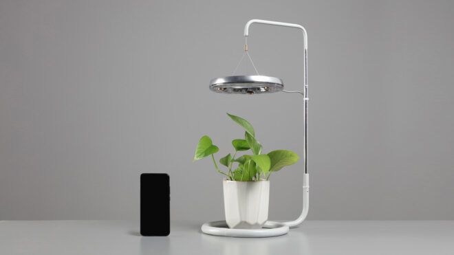The full CURA hovering above a potted plant with a black device standing next to it