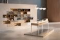 A showroom area with a wall of food. In front of it is a table with light hanging above it