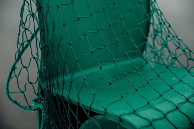 An up-close photo of green net tossed over a green chair