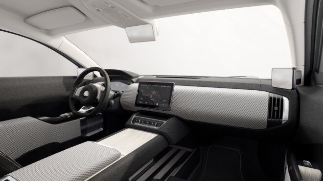 The inside steering wheel and dashboard area with a large touchscreen navigation system in the center