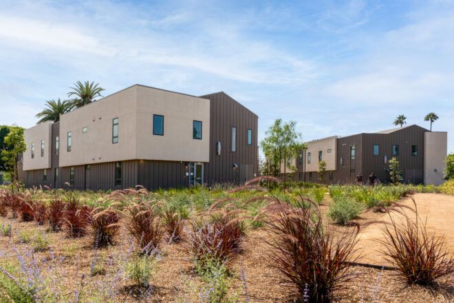 View from the back of a healthcare building surrounded by neatly-planted shrubs