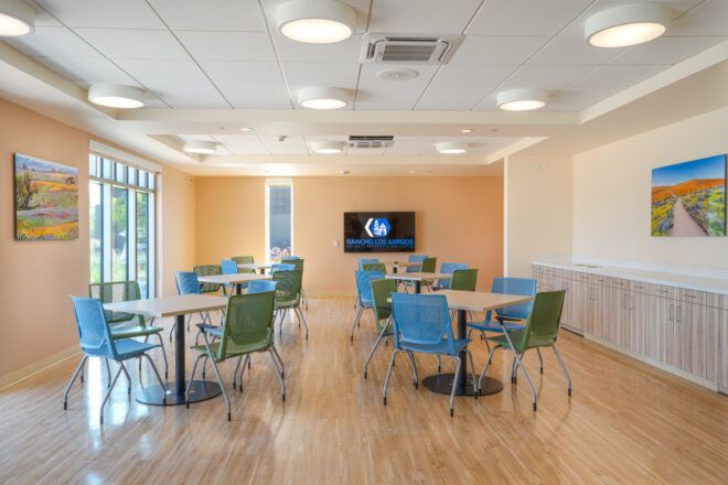 Dining area with square tables with four chairs each and a TV on the back wall