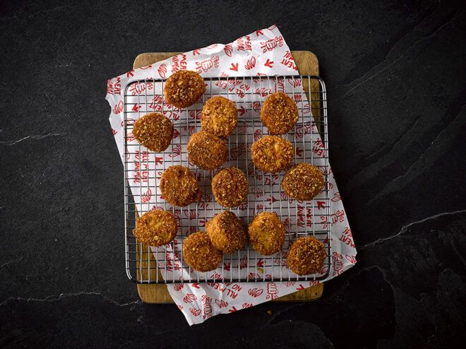 A black metal tray filled with vegan chicken nuggets