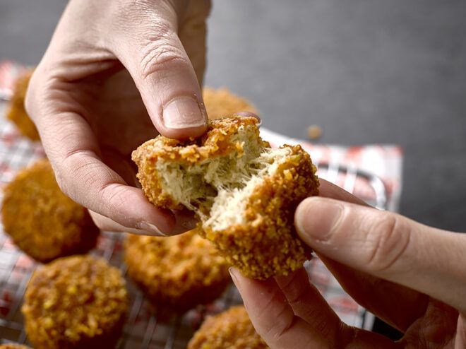 Two hands splitting open a vegan chicken nugget