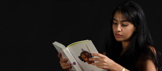 Designer Nuhayr Zein seated on the floor, resting her arms on an ottoman from Leukeather's SEEDS Series, reading a book