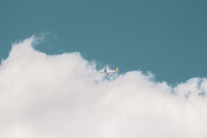 an airplane in a sky among clouds