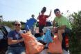 A group of people on a vehicle with bags to collect trash