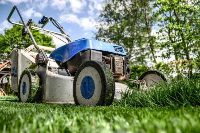 A blue lawnmower on a green grass