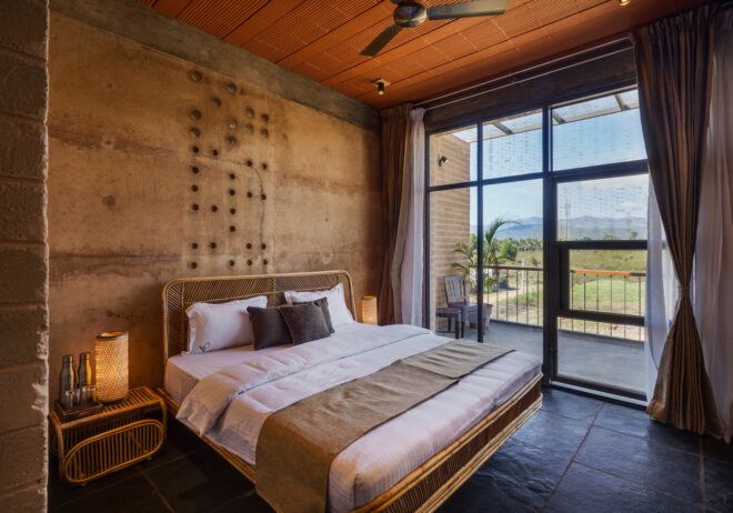 A bedroom with a floor-to-ceiling window that opens to the balcony