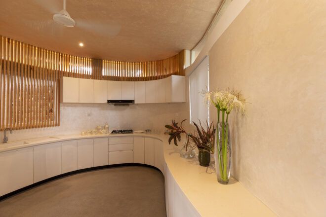 A white kitchen area with curved flowy walls