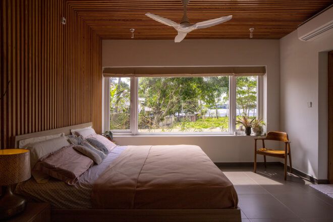 A bedroom with exposed wooden beams and a wall of windows