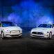 Two white Mustang EV facing each other with a blue light behind it