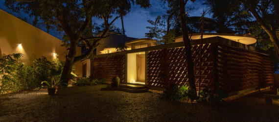 The Cloud House lit up at night peaks lights through the slits