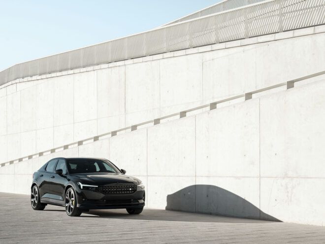 A black vehicle driving down a concrete slope
