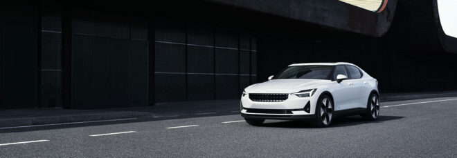 A white car driving down a street