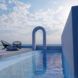 An archway surrounded by a pool and the sea in the distance