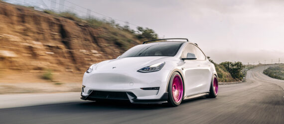 A white car zooming down a highway